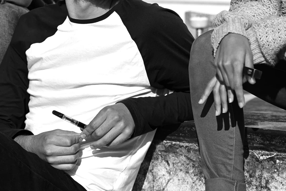 Hands holding thc vape cartridges and delta-8 disposable vape pens
